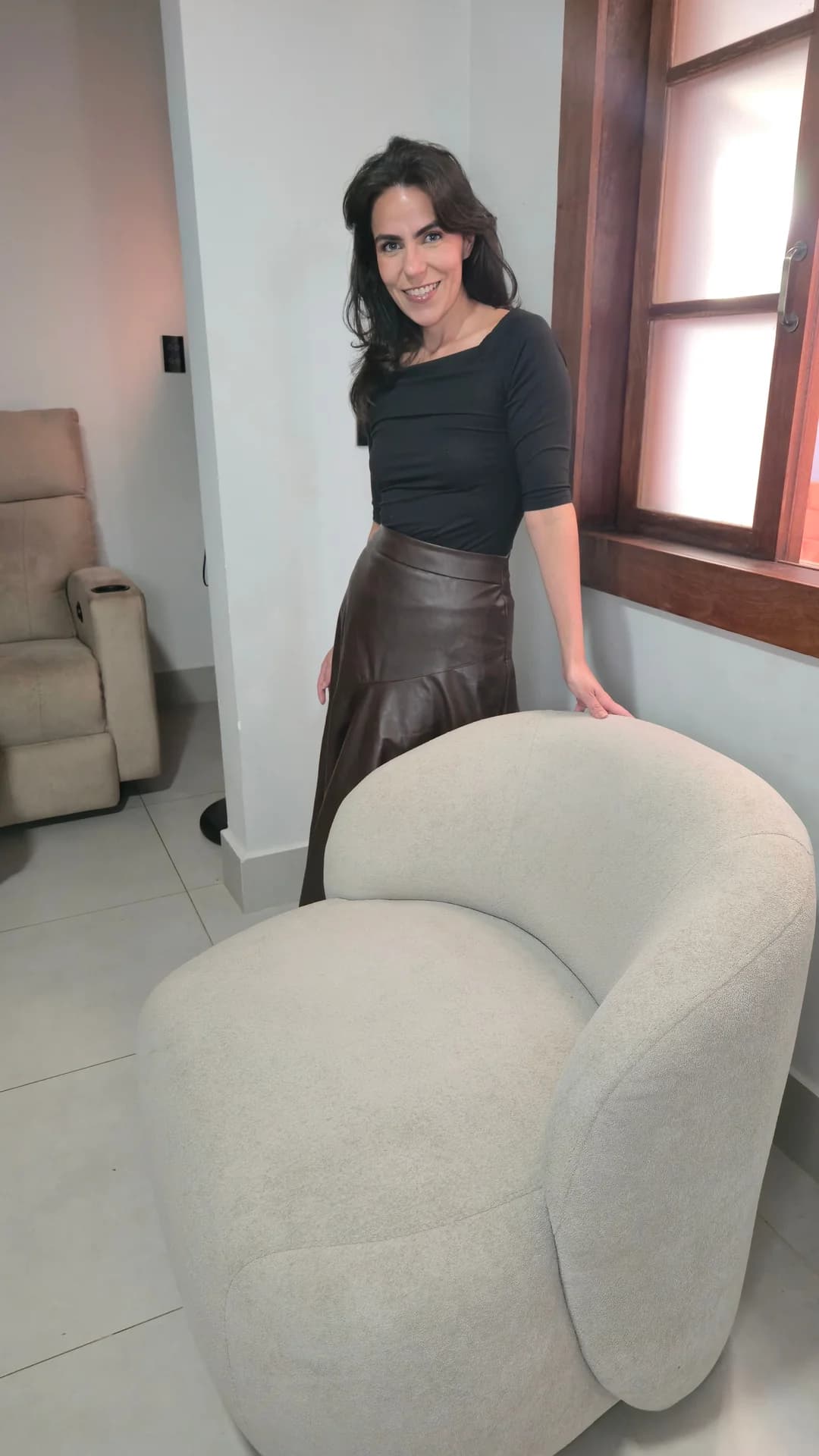 Cecília destacando o design escultural e a base giratória da Poltrona Moon.