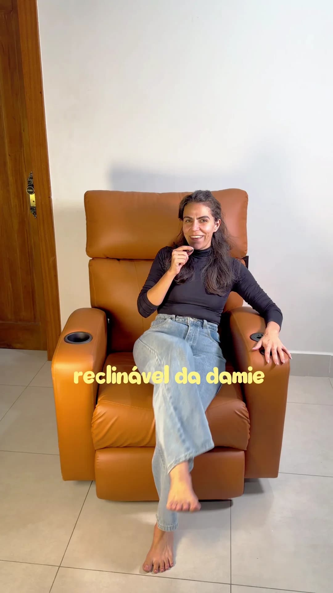 Cecília Mauad sentada na Poltrona Reclinável Damie 2.0 na cor caramelo.